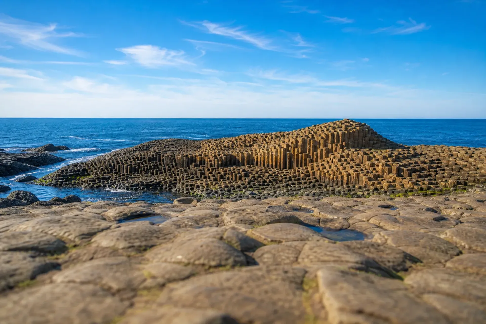 Ireland-The hexagonal basalt columns of the Giant's Causeway on a sunny day during the Donegal Belfast coastal tour.