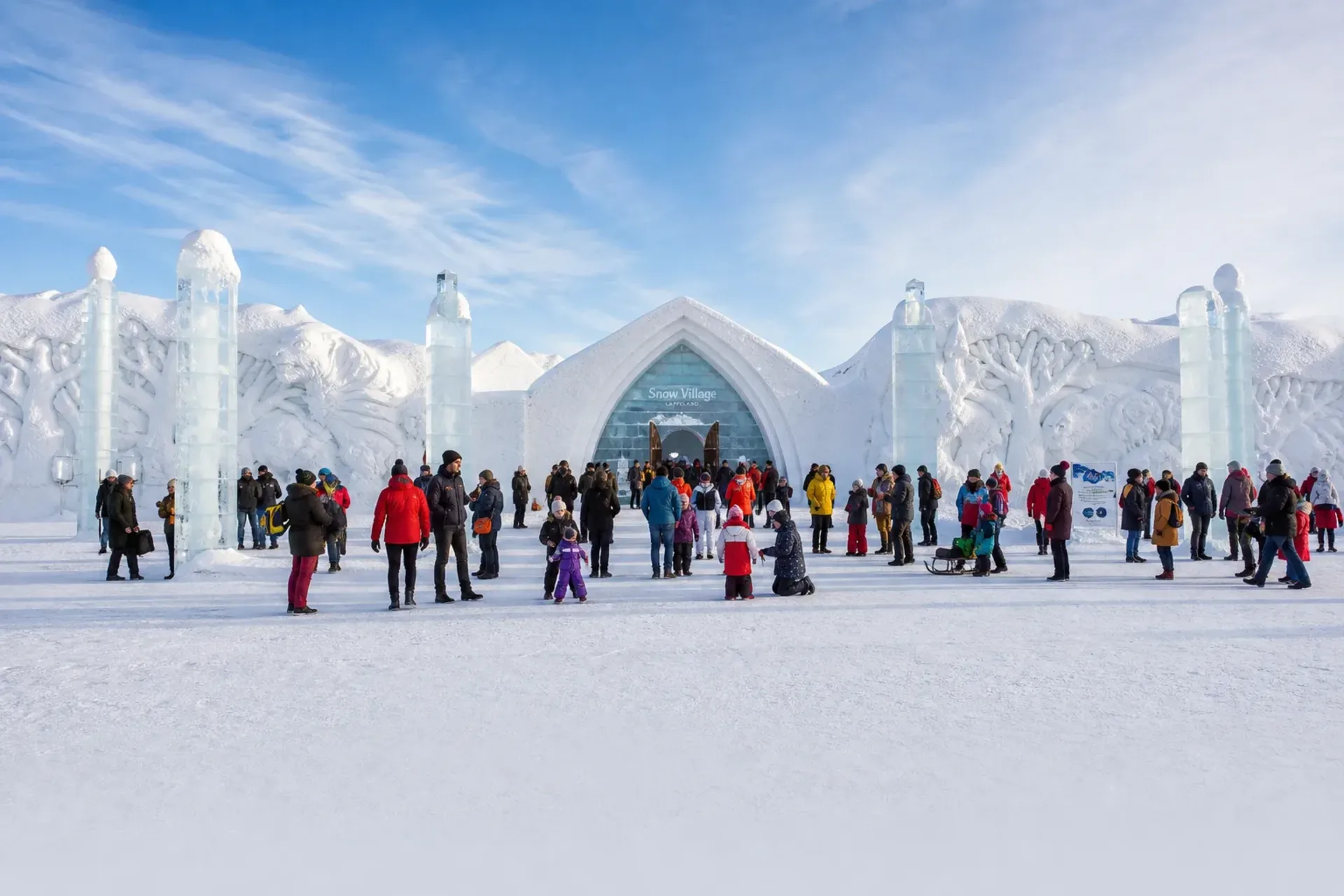 Finland-Families exploring the spectacular ice structures of the Snow Village on a Lapland Santa trip.